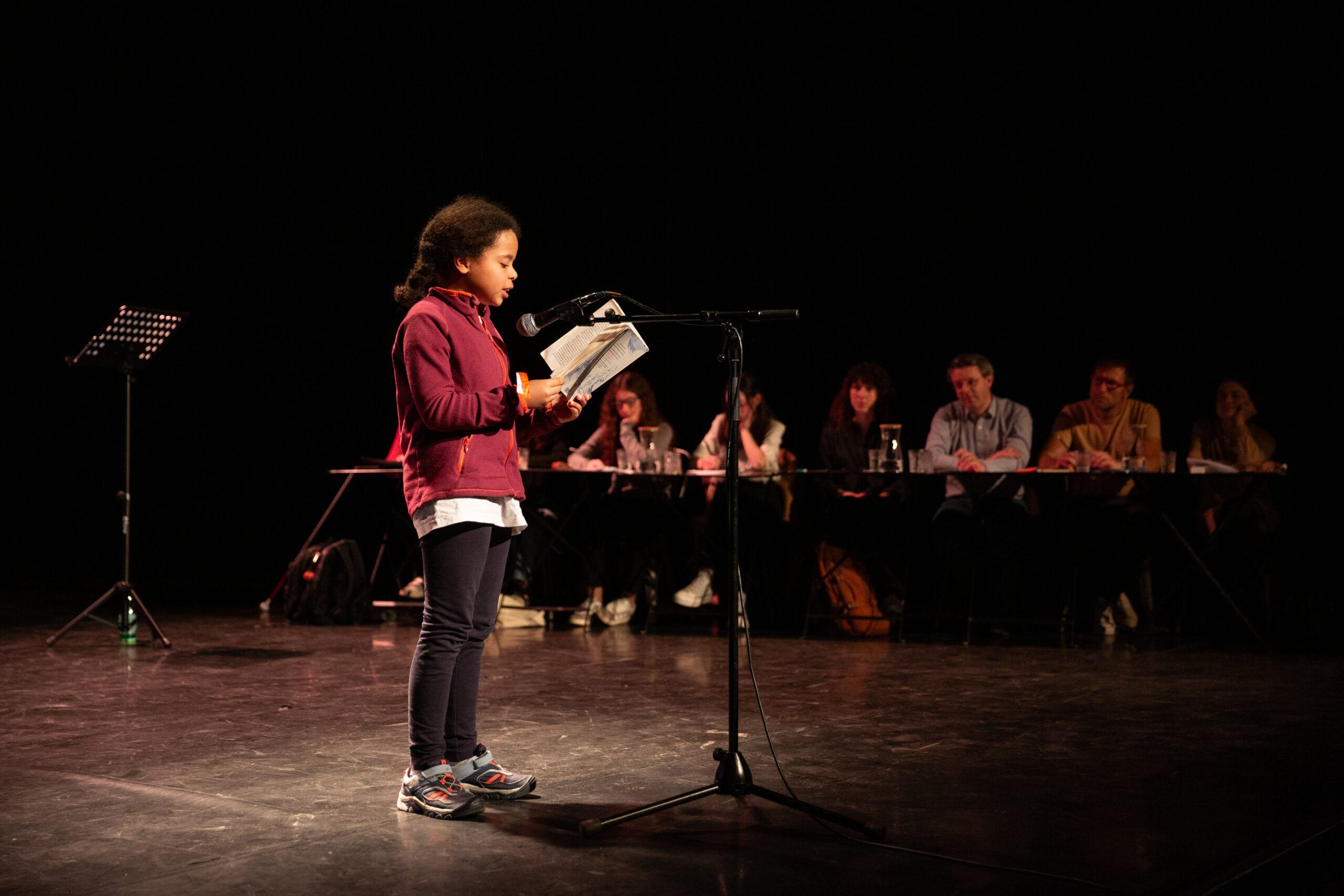 Jeune candidate lisant à la demi-finale régionale AURA des Petits champions de la lecture 2024